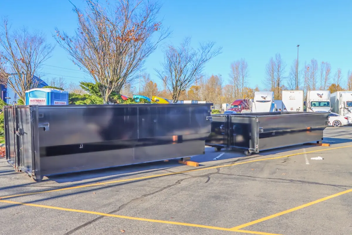 Professional dumpster rental service with roll-off container on residential driveway in Post Falls